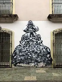 Military figure with binoculars labeled "PM" sitting atop pile of skulls and skeletons