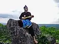 A Banjar man playing the panting musical instrument