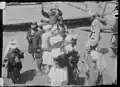 1929 approx. Kunisht (Rumbur Sheikhandeh), Rumbur Valley, Chitral, NWFP, Pakistan Photograph (nr. 1 of 3) reproduced from Georg Morgenstierne's unique film documentary from Chitral. Overview picture from the Kati dance. The male Kati dancers are dressed as usual for this occasion in their best clothes, silk costumes (talar) and turbans. The dance on the ground beside the dancing floor is called Zhige.