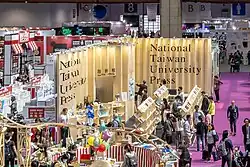 A crowded fair with a sea of people in front of a booth