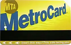 A rectangular yellow transit farecard with a black strip and has the words "MTA" and "Metro Card" on it