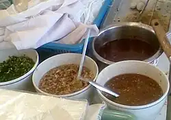 Nam tok-noodle ingredients in Thailand. The upper right pot has raw pig's blood that will be added to the noodle soup preparations