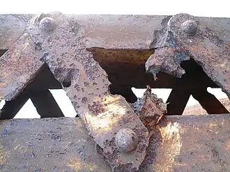 Rusted and pitted struts of the 70-year-old Nandu River Iron Bridge