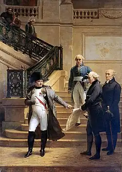 Painting of four men near and on a staircase. A man on the right shows some paper to the man on the left (Napoleon) who’s hand gesture indicates that he rejects this document