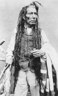 Poundmaker carrying a Hudson's Bay point blanket