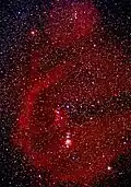 Long exposure of Orion with red clouds of ionized hydrogen (H-alpha). The big bow on the left is Barnard's Loop.