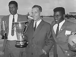 Dutch baseball players Hamilton Richardson, Han Urbanus, and Hudson John smiling for photographers and holding trophies
