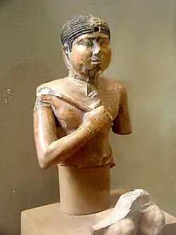 Bust of the statue of a king, holding a mace