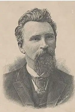 A portrait of a middle-aged German-American man with short hair, a mustache, and a long beard wearing a suit.