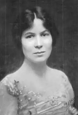 A young white woman with dark hair and eyes, wearing a sequined gown