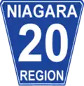 Niagara Regional Road 20 marker. While Niagara generally conforms to the standard Ontario "flowerpot" design, the markers are white-on-blue rather than the more traditional black-on-white and have rounded corners.