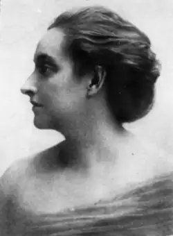 A white woman with her hair in an updo, photographed in profile