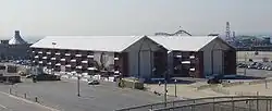 A rectangular building constructed from stacked shipping containers with large windows