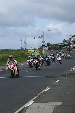Several motorcycle riders racing on a public road