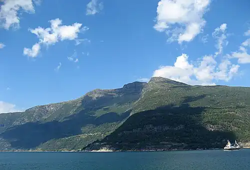 View of the fjord from the ferry dock at Brimnes. The route on the north side of the fjord is Norwegian National Roads 7 and 13 between Bruravik and the Vallavik Tunnel.