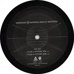 Side one of a black record with a symbol covering the surface and letters mentioning the two versions of the song