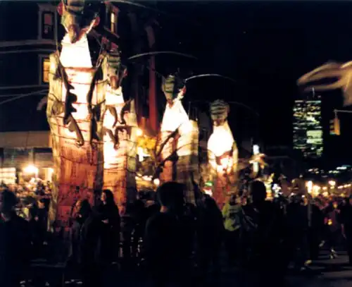 Twenty-foot illuminated caterpillars — animated pageant sized puppets designed by Alex Kahn of Processional Arts Workshop — transform Manhattan's Greenwich Village in 1998 (the former Twin Towers are prominently seen in the background)