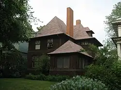 Exterior view of the George W. Smith house from right front corner to demonstrate a similar porch design and main house massing to the Hills House. The Smith house has the same roof, but its eaves are shallower and flared ends are less pronounced.