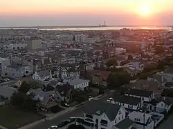 A view over a town early in the morning with a power plant smokestack in the background