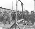 An Austrian-Jewish survivor points out the gallows to General Dwight D. Eisenhower.