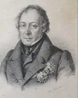 An order man in formal attire, an overcoat with a high collar and cravat his breast is decorated with resplendent medals.