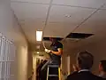 Electrician with head in the ceiling