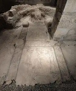 A floor from a Romanesque-era church, showing decorative carved elements of people praying and looking up to God.