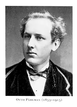 A black-and-white studio portrait of a man wearing a suit and bow tie.