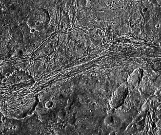 An image of the strained and heavily damaged Saltu crater (lower left) within Nicholson Regio, taken by the Galileo space probe in April 1997.