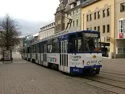 Coupled pair of two-section blue and white trams