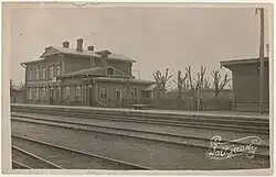 A sepia-tone image showing the main building of Paldiski railway station from across the tracks, captured in 1924.