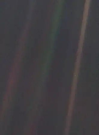 Dark grey and black static with coloured vertical rays of sunlight over part of the image. A small pale blue point of light is barely visible.