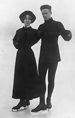 Helfrid Palm wears a dress almost to her ankles, and Agard Palm wears a hip-length coat and tights