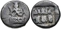 Coin of the Panchalas of Ahichhatra (75-50 BCE). Obv Indra seated facing on pedestal, holding bifurcated object. Rev Idramitrasa in Brahmi, Panchala symbols.