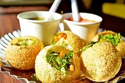 Crispy, round shells with an herb and vegetable filling. Two sauces are served with it.