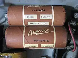 Two 8&nbsp;μF, 525&nbsp;V wound wet aluminum electrolytic capacitors in paper housing sealed with tar out of a 1930s radio.