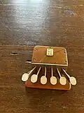 Only six keys are on this wooden precursor to a braille display. A refreshable braille cell is on the opposite side of the keys.