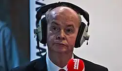 Pat Carey being interviewed while wearing radio headphones