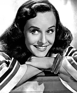A woman with long, dark hair, smiling