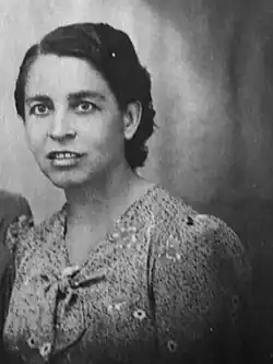 Pepita Not, wearing short dark hair and a floral dress