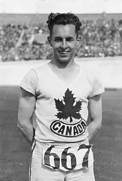 Man wearing a white track and field bib with a maple leaf logo