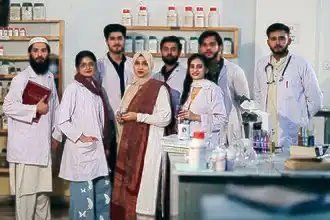 Students and faculty of Hajvery University during a practical session in the Pharmacy laboratory.