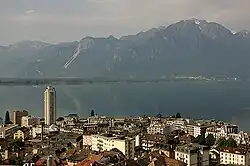 Looking past a city towards a lake, with mountains behind