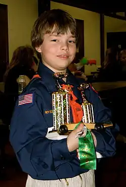 Image 11A happy Cub Scout holds a winning pine car