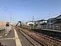 A view from platform 1 with platform 2 to the right. The level crossing can be seen in the background.