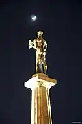 Statue of the Victor at night with the Moon and Ursa Minor in the background.