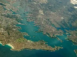 Sydney Harbour with the North Shore extending from its northern side (right) with Sydney CBD (left) and Eastern Suburbs (bottom) on its southern shore.