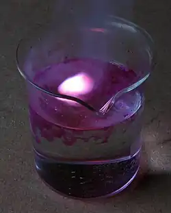 Potassium reacting with water, producing heat, hydrogen gas, and a lilac flame.