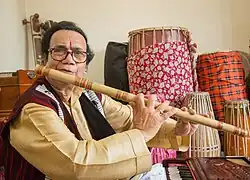Sarma playing flute at his residence