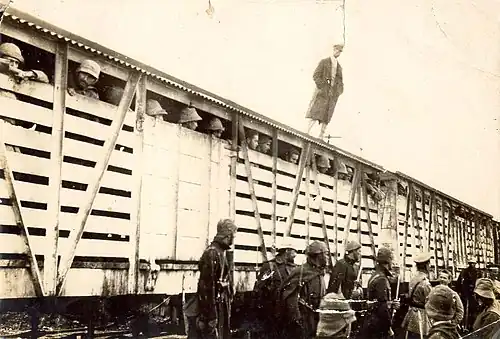 A vented boxcar, with soldiers looking out